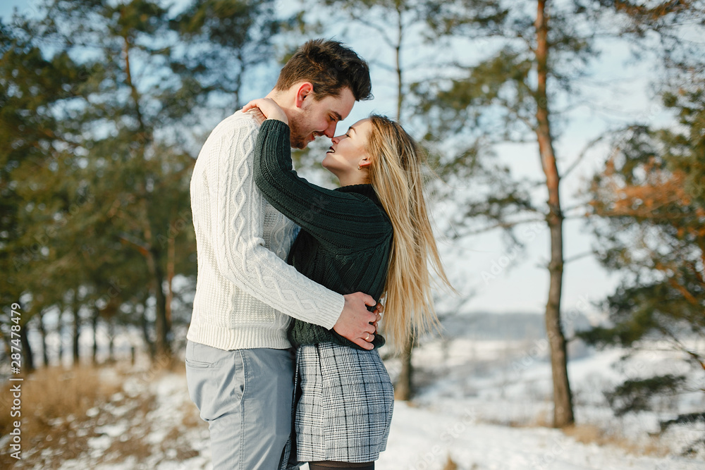 happy couple kissing and hugging in the park on a snowy winter day happy couple kissing and hugging in the park on a snowy winter day
