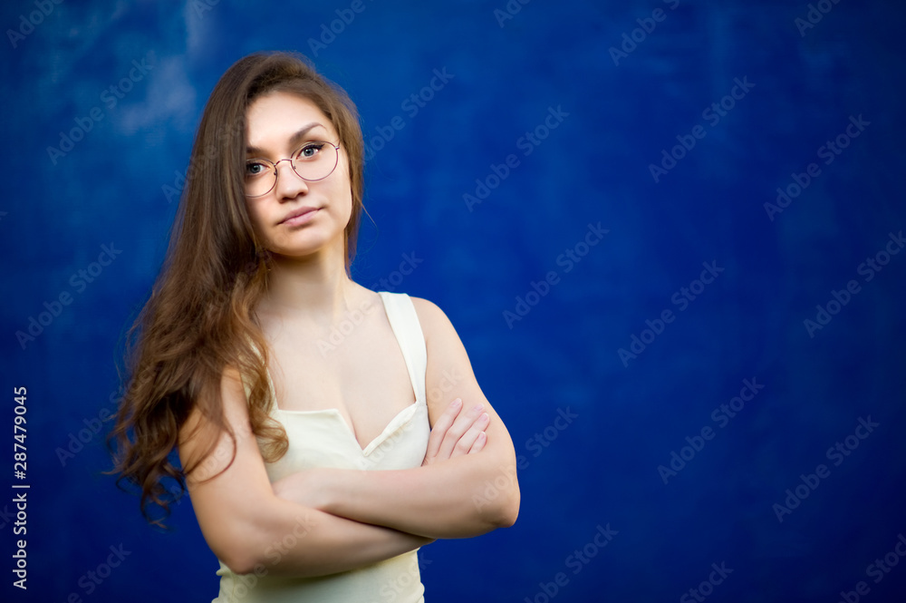 girl with glasses on a background of blue textured wall girl with glasses on a background of blue textured wall