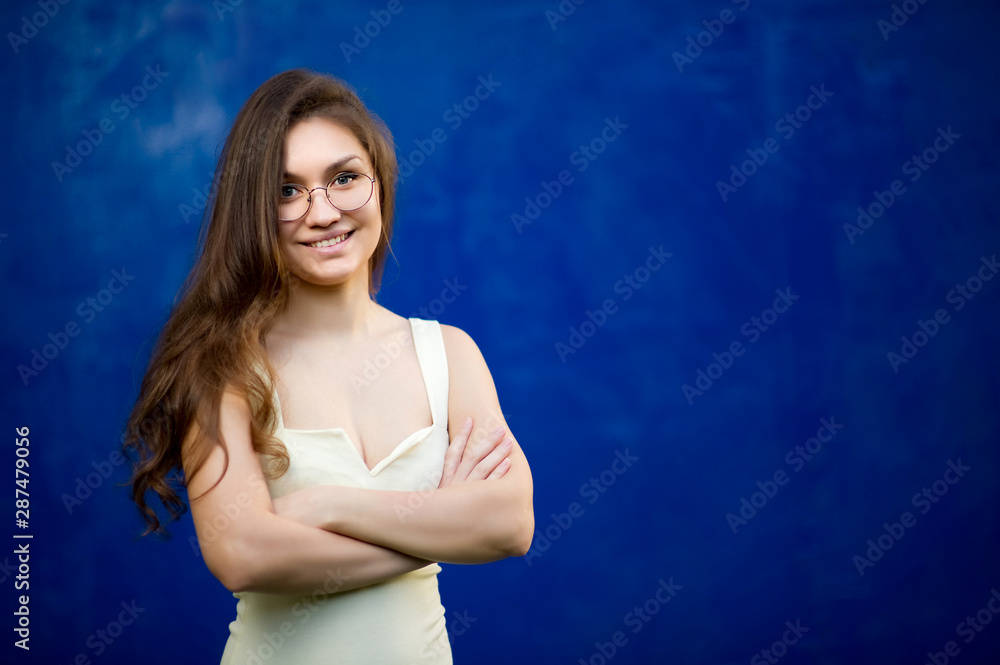 girl with glasses smiling on a background of blue wall girl with glasses smiling on a background of blue wall