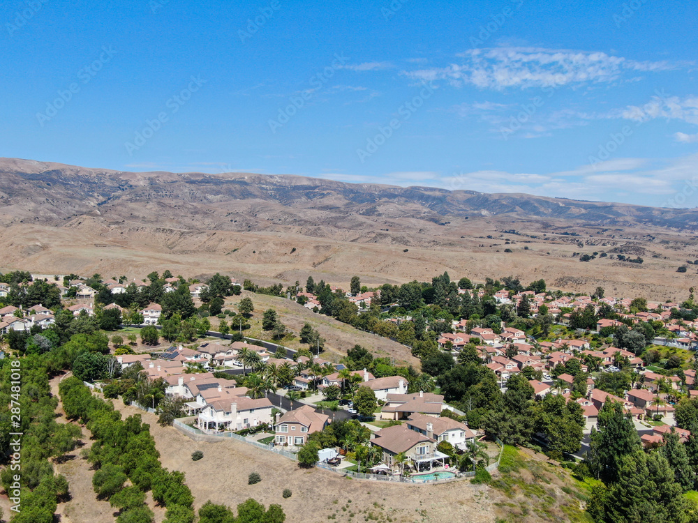 Aerial view of small neighborhood with dry desert mountain on the background in Moorpark