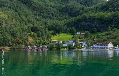 A row of red small house with small boats at Flam, Norway. July 2019