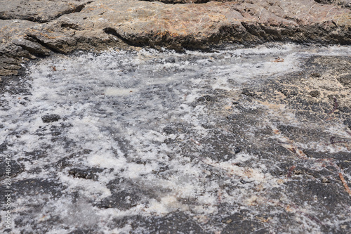 Natural sea salt on the stone beach in Crete, Greece.