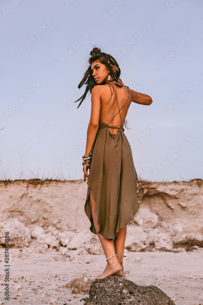 Fototapeta premium beautiful young boho style woman on the beach at sunset