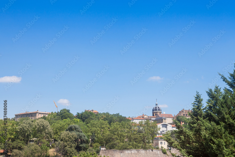 Panorama of Colline de la Croix Rousse Hill with a focus on Chartreux district in Lyon, France, with the roman catholic church of Saint Bruno des Chartreux surrounded by a park in summer.
