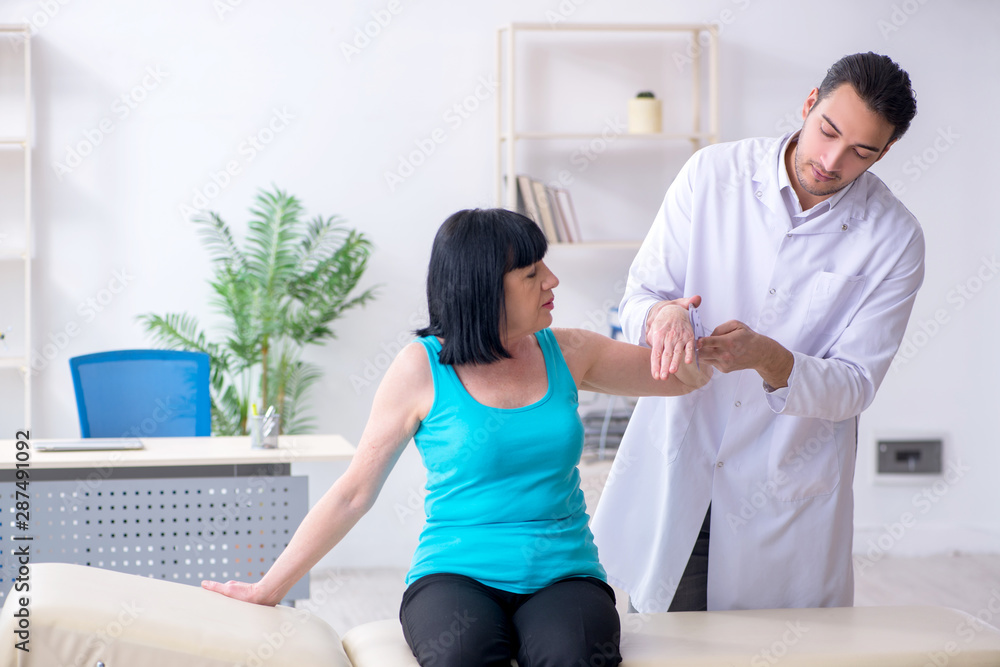Obraz premium Young male doctor examining old female patient