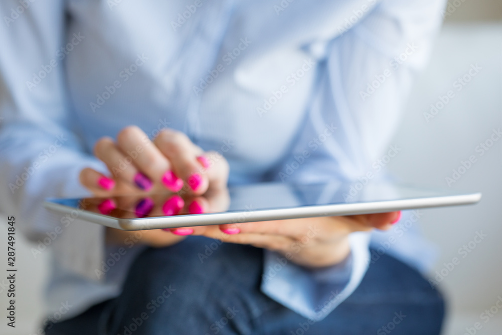 Woman using tablet computer, close-up photo