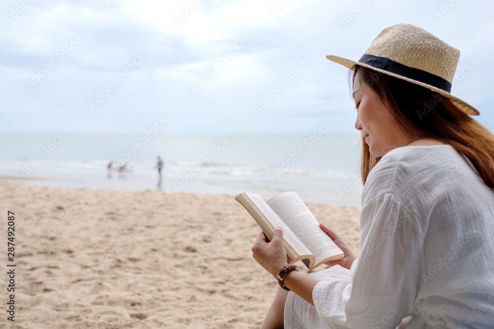 A beautiful woman sitting and reading book on the beach chair with feeling relaxed