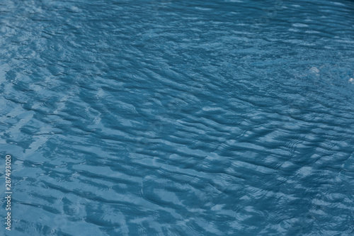 Blue swimming pool edge with refection of water ripple