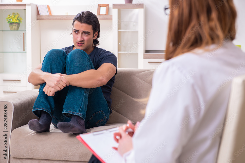 Obraz premium Young male patient discussing with female psychologist personal