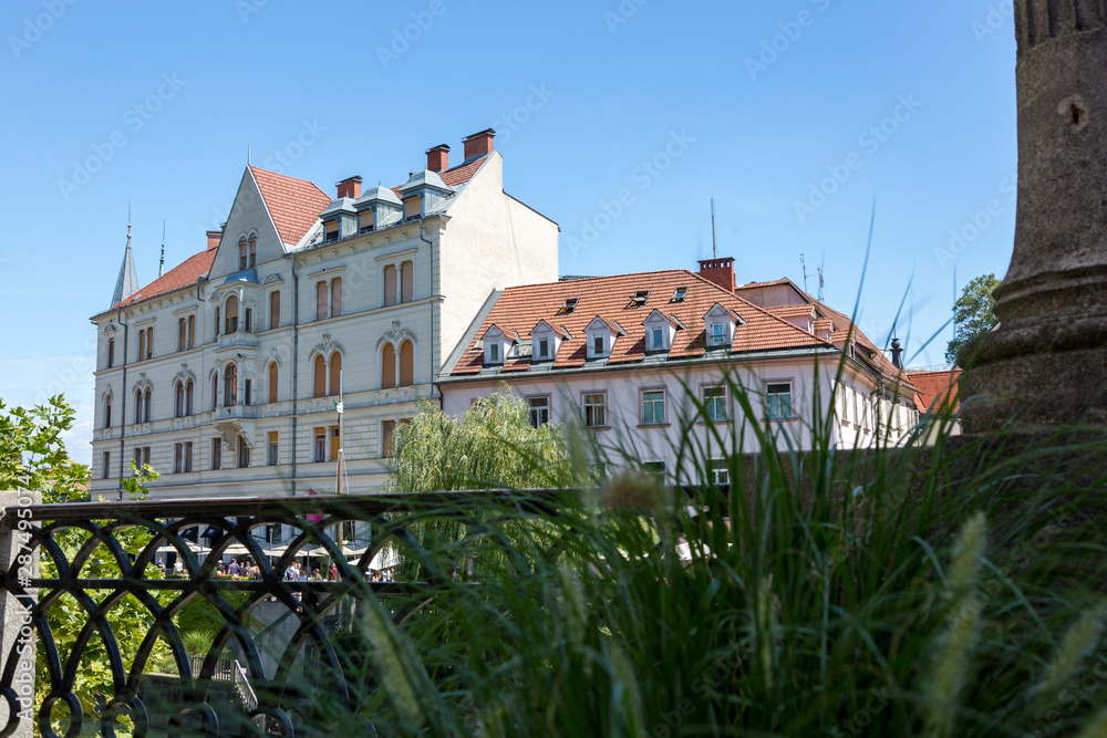 Ljubljana, Slovenia - August 15, 2019: Houses and a fence on the embankment of the Ljubljana River in Ljubljana