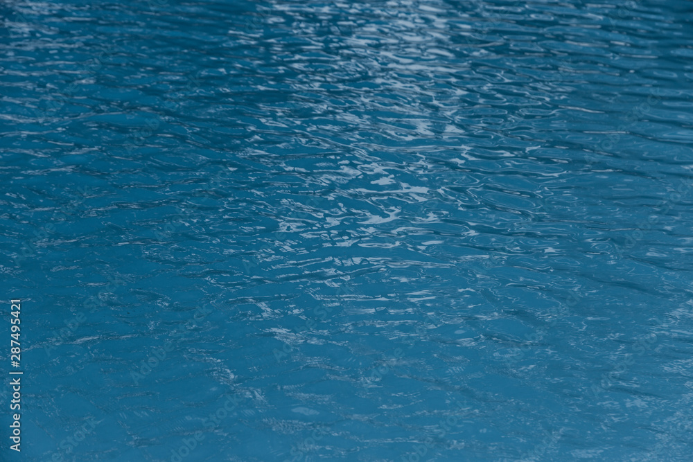 Blue swimming pool edge with refection of water ripple