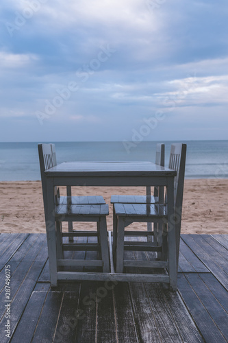 Vintage tone of White table for dinner on the beach and sky