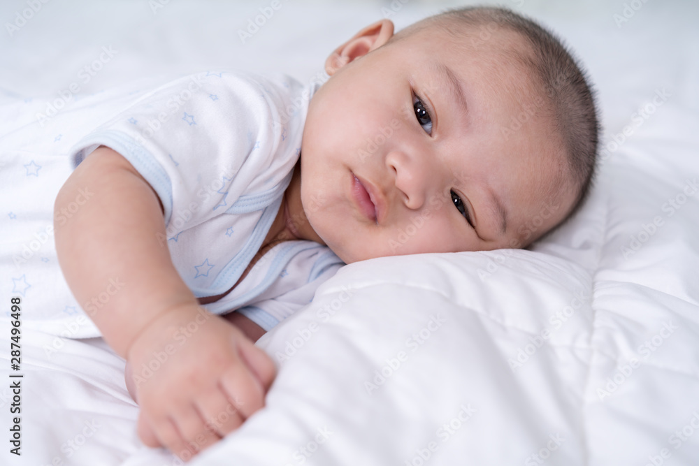 happy baby lying on a bed