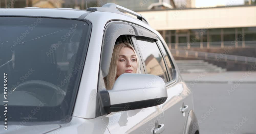 Portrait of a young beautiful blonde with a pensive look on the seat of her car. Portrait of a young beautiful blonde with a pensive look on the seat of her car.