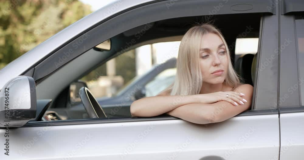 Portrait of a young beautiful blonde sitting at the wheel of her car looked and smiled at the camera. Portrait of a young beautiful blonde sitting at the wheel of her car looked and smiled at the camera.