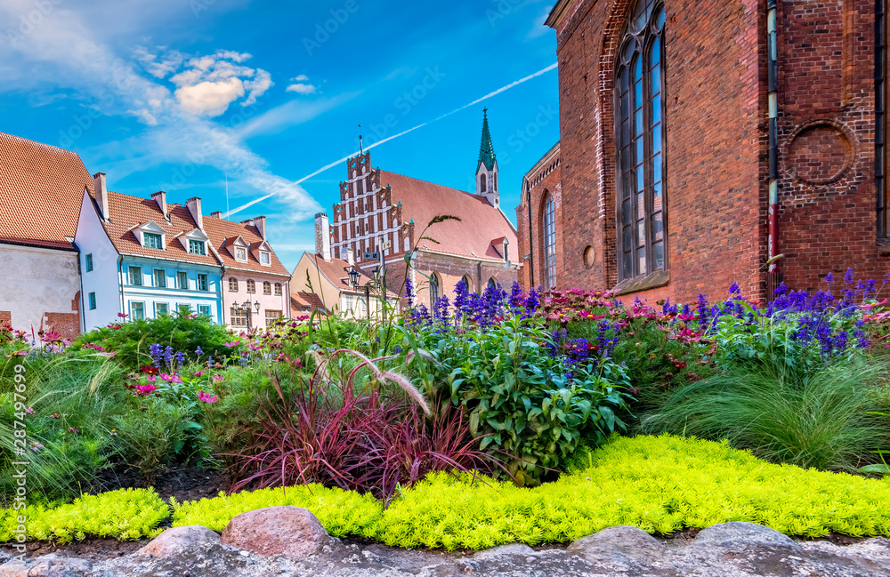 Floral garden in front of St. John's Church that is the Evangelical Lutheran Church in old Riga. Riga is the capital of Latvia and famous tourist city in Baltic region, here tourists will able to feel