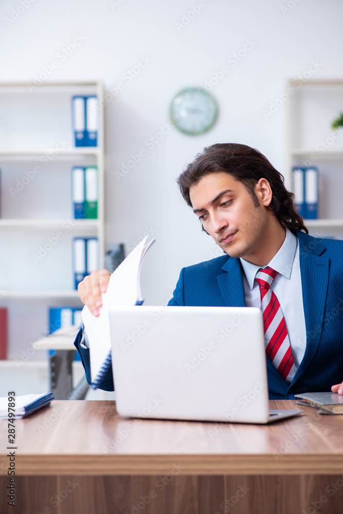 Young male businessman working in the office Young male businessman working in the office