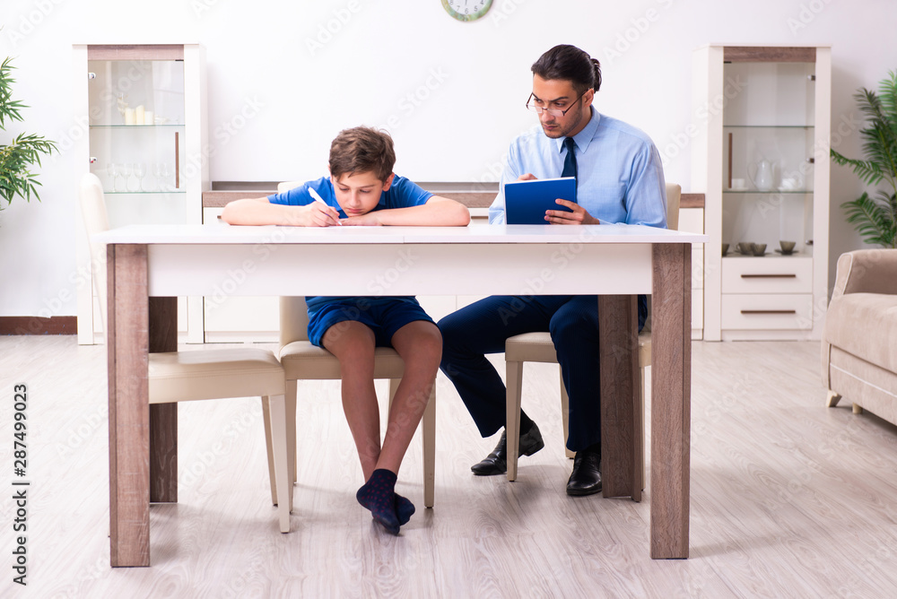 Busy father helping his son to prepare for exam Busy father helping his son to prepare for exam