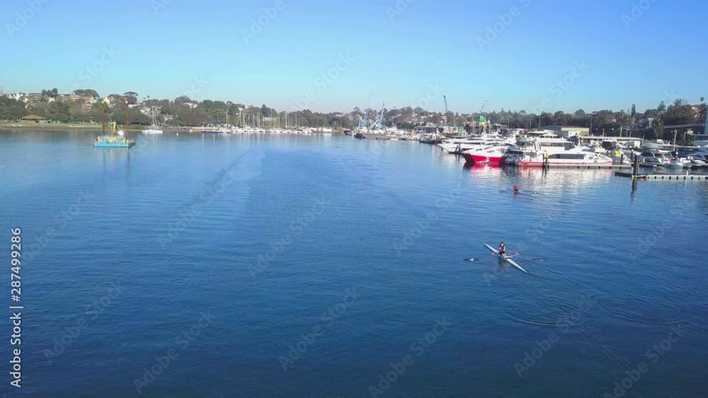A Kayak coming towards the camera, paddeling along some big motorboats A Kayak coming towards the camera, paddeling along some big motorboats