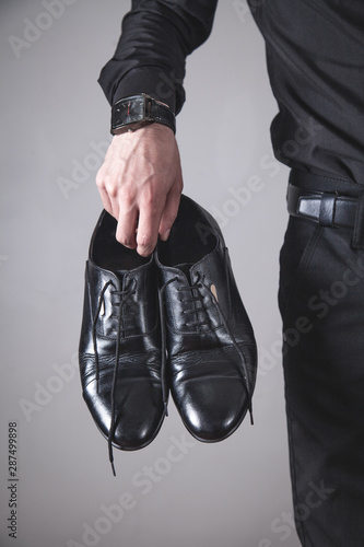Man holding black shoes. Fashion concept