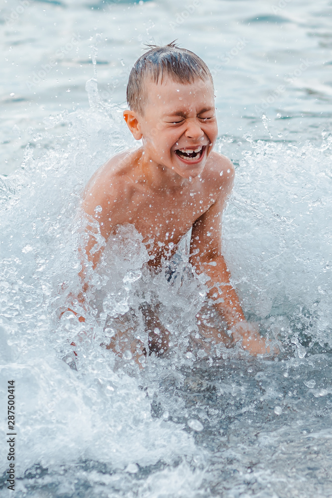 little girl in a swimsuit splashing her legs in the sea