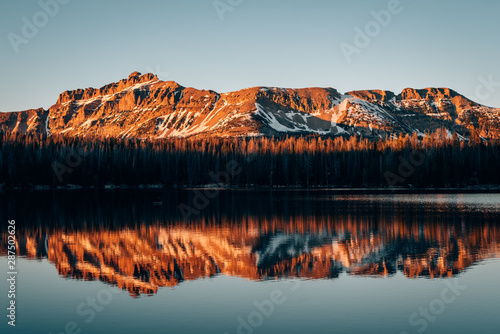 Snowy mountains reflecting in Mirror Lake, in the Uinta Mountains, Utah photo