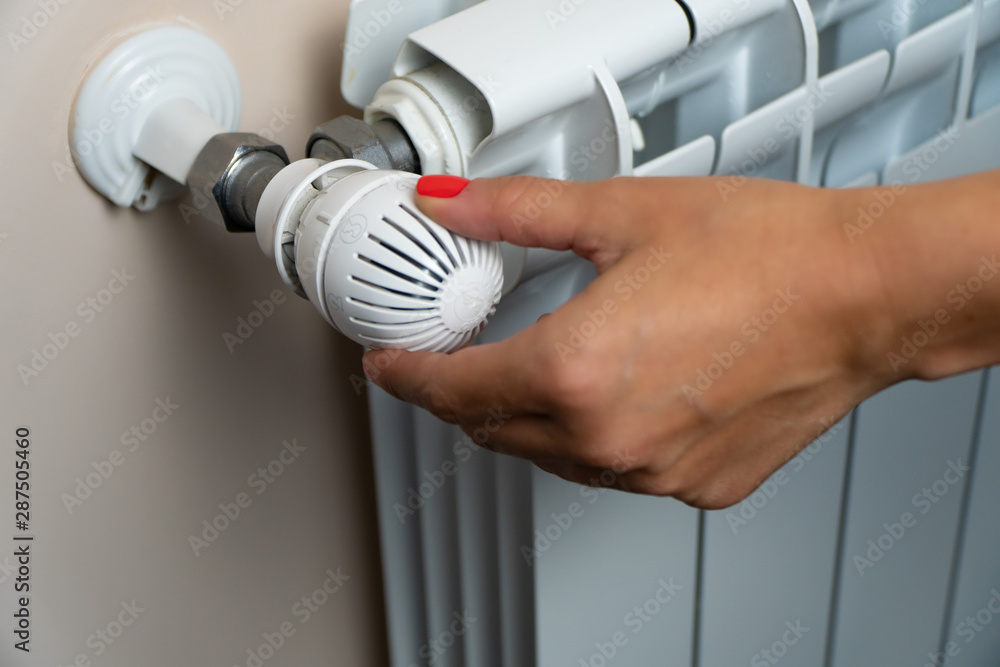 Woman Hand Adjusting The Temperature By Thermostat Woman Hand Adjusting The Temperature By Thermostat