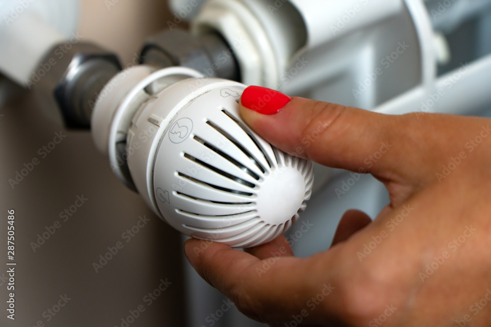 Woman Hand Adjusting The Temperature By Thermostat Woman Hand Adjusting The Temperature By Thermostat
