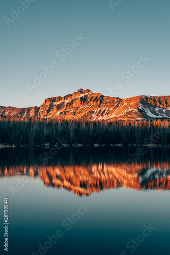 Snowy mountains reflecting in Mirror Lake, in the Uinta Mountains, Utah photo