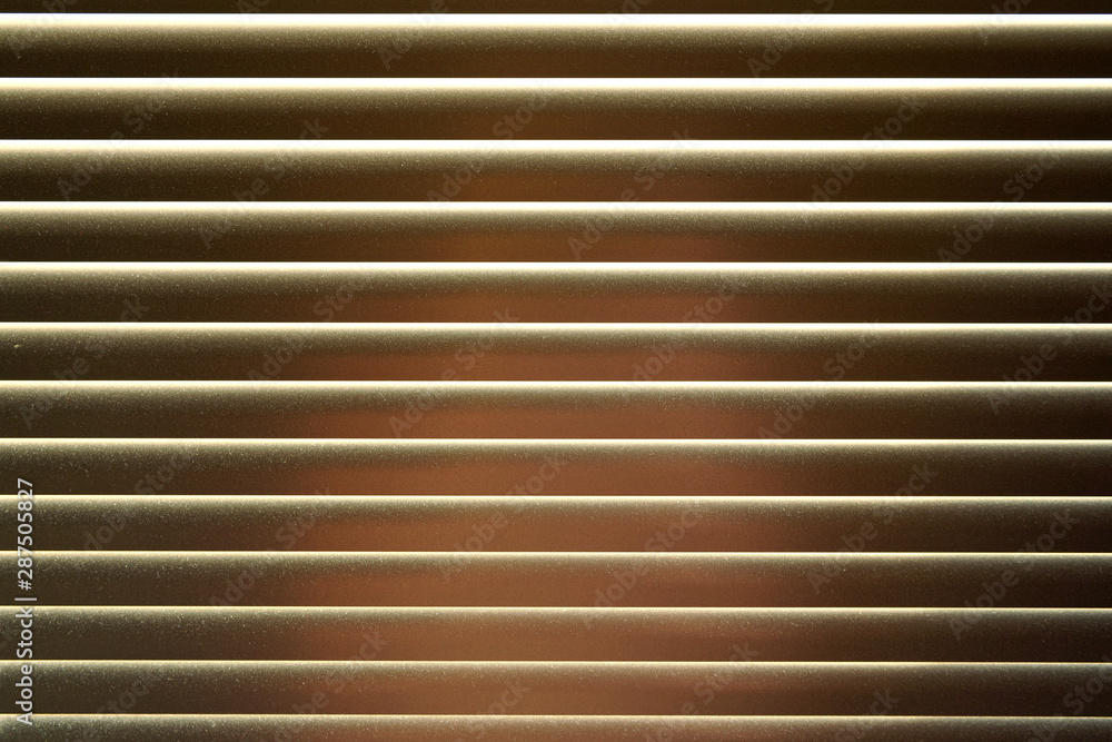 Detail on metal window blinds, some light reflects on, dust visible, abstract geometric background Detail on metal window blinds, some light reflects on, dust visible, abstract geometric background