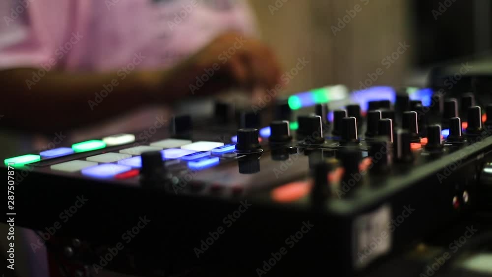 Slow motion close up shallow depth of view of a person operating a music mixing console Slow motion close up shallow depth of view of a person operating a music mixing console