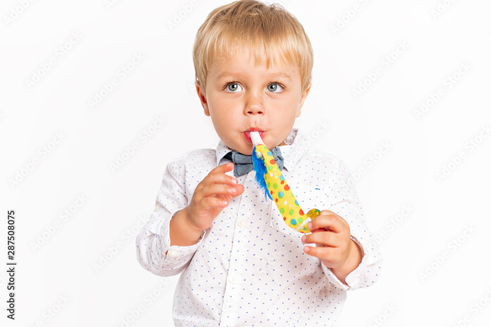 Cute little boy, jeans and shirt blowing in the birthday tune Cute little boy, jeans and shirt blowing in the birthday tune