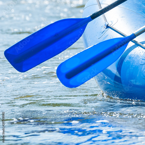 Rafting. Close-up of oars and part of a rubber inflatable boat on the water.