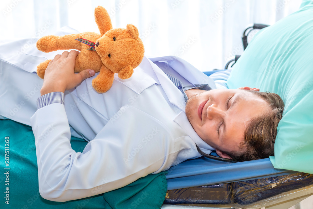 Pediatrician (doctor) sleeping and hug teddy beer on bedroom hospital. Good dream and relax. Pediatrician (doctor) sleeping and hug teddy beer on bedroom hospital. Good dream and relax.