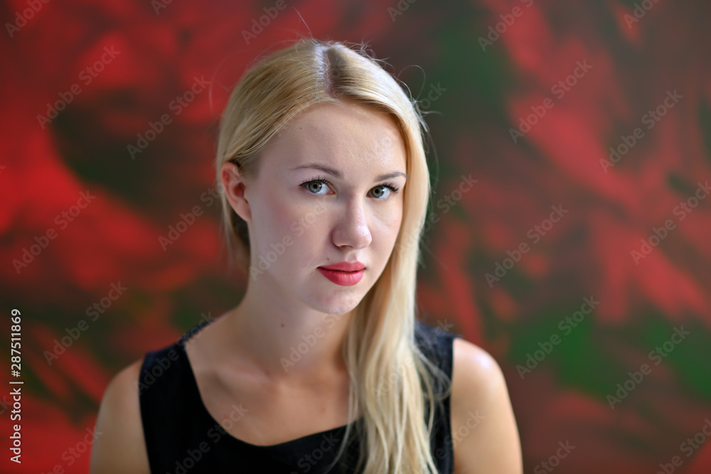 A close-up portrait of a pretty blonde girl with excellent facial skin and light makeup on a colorful background. Beauty, brightness, happiness.