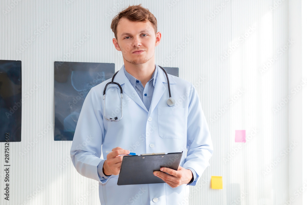 Happy man doctor possing and wearing a stethoscope on hospital room. Happy man doctor possing and wearing a stethoscope on hospital room.