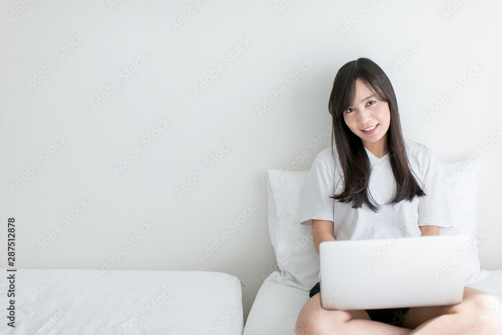 Young woman drinking coffee at home in her bed and checking her laptop Young woman drinking coffee at home in her bed and checking her laptop