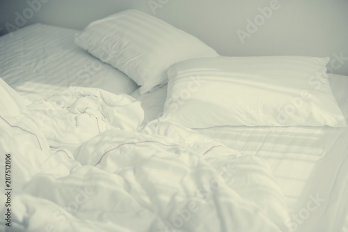 bedroom with two pillows and crumpled bed sheet, after waking up in the morning