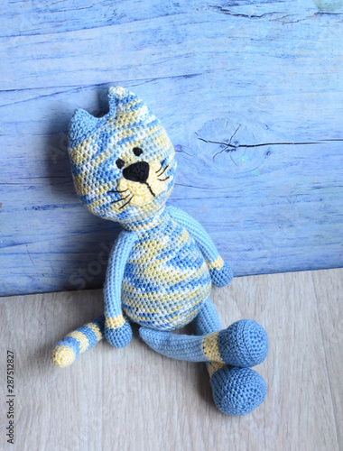 Knitted blue striped handmade crafted cat. Children's toy. Crochet pattern.