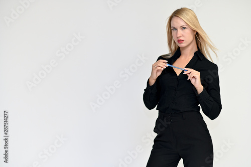 Portrait of a pretty blonde girl in a black suit on a white background. Beauty, brightness, happiness, business look. Shows different emotions in different poses.
