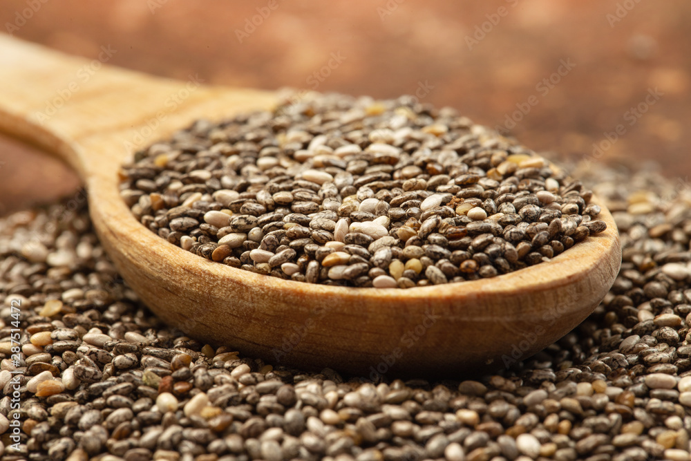 Chia seeds in wooden spoon Chia seeds in wooden spoon
