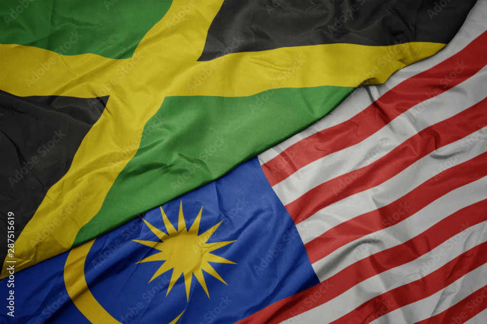 waving colorful flag of malaysia and national flag of jamaica.