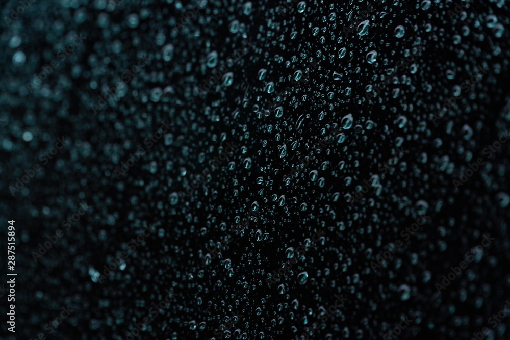 Water raindrops on a shiny dark black surface Water raindrops on a shiny dark black surface