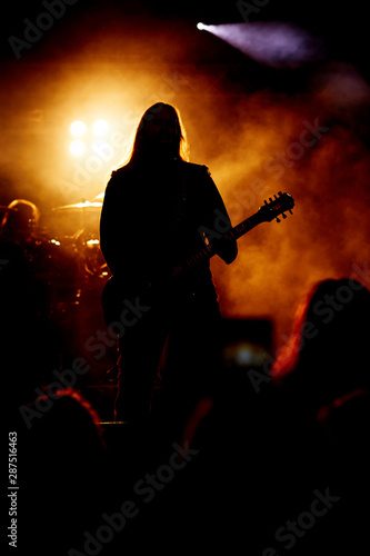 A heavy metal star playing guitar. Hard rock guitarist in concert.