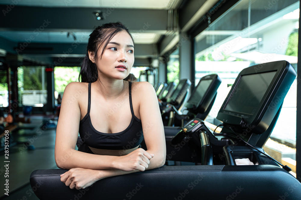 Beautiful fitness women prepare for running at the treadmill in the gym. Beautiful fitness women prepare for running at the treadmill in the gym.