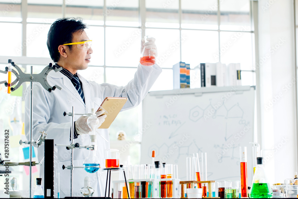 Asian man scientist with test tube making research in clinical laboratory.Science, chemistry, technology, biology and people concept Asian man scientist with test tube making research in clinical laboratory.Science, chemistry, technology, biology and people concept