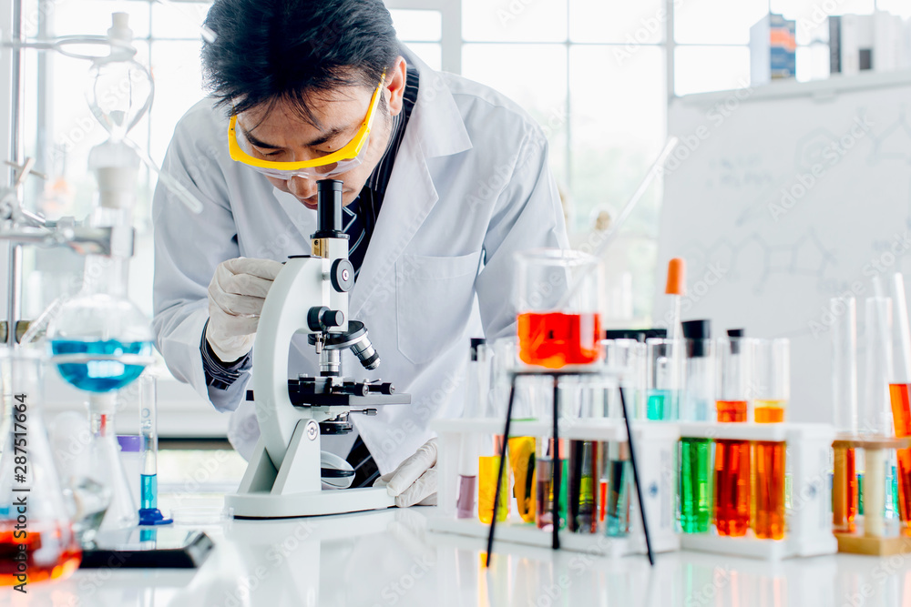 Asian man scientist with test tube making research in clinical laboratory.Science, chemistry, technology, biology and people concept Asian man scientist with test tube making research in clinical laboratory.Science, chemistry, technology, biology and people concept