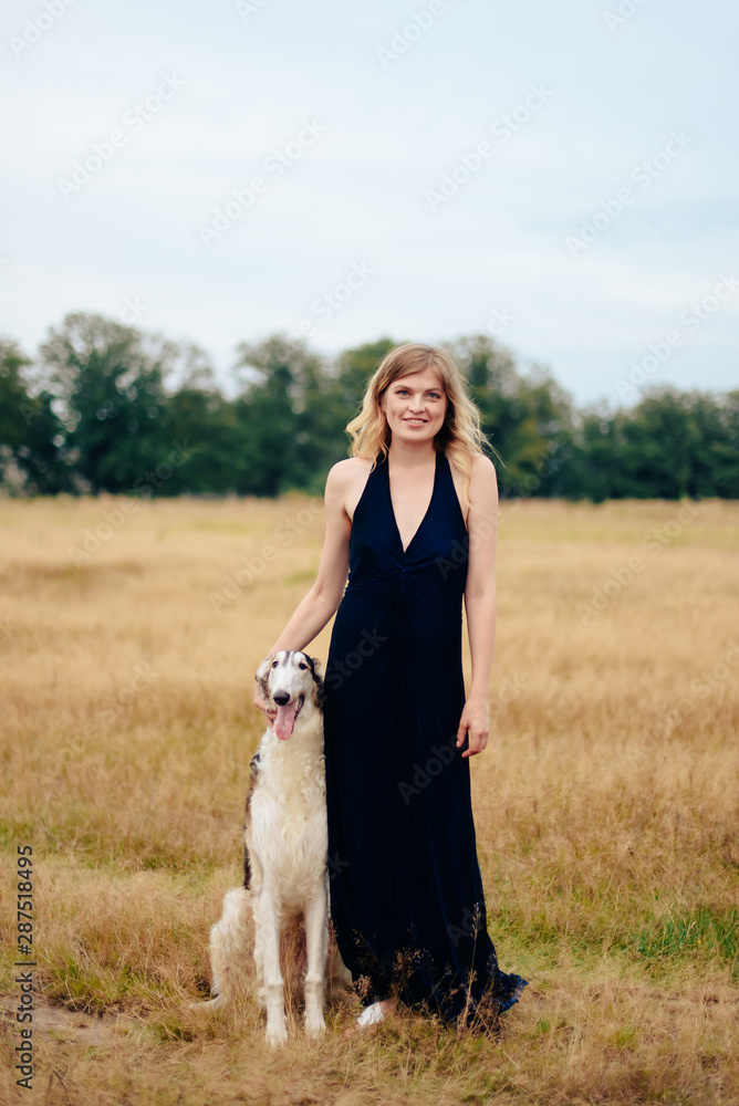 beautiful girl in a dress on nature with Russian greyhound dogs beautiful girl in a dress on nature with Russian greyhound dogs