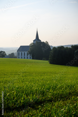 Kirche und Wiese in Sommer Landschaft