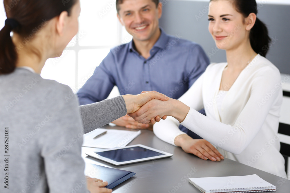 Group of business people shaking hands after discussing questions at meeting in modern office. Handshake close-up. Teamwork, partnership and agreement in business concept Group of business people shaking hands after discussing questions at meeting in modern office. Handshake close-up. Teamwork, partnership and agreement in business concept